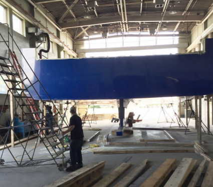 Hull blocked up and supported by stands in boat shed.